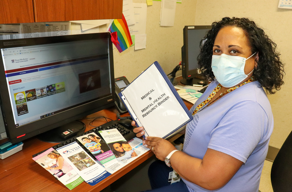 Lissette "Mitzy" Liriano holding a Medical and Mental Health Resource Binder